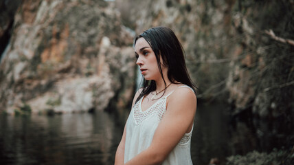 Joven modelo con vestido blanco posa dentro de un lago