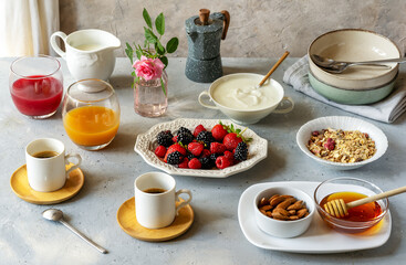 Obraz na płótnie Canvas Breakfast in the morning with berries, muesli, coffee, milk, yogurt, honey, almonds and juice over grey background with rose in vase 