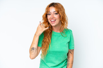 Young caucasian woman isolated on white background making phone gesture. Call me back sign