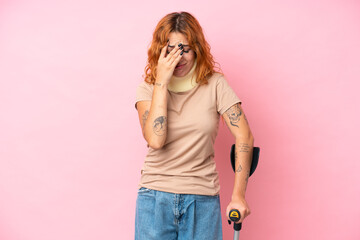 Young caucasian woman wearing neck brace isolated on pink background with tired and sick expression