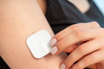 woman sticks a medical microneedle plaster - 625854078