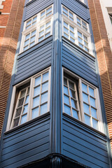 House detail with blue wood panels and windows,