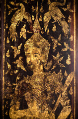 Chiang Mai, Thailand. JAN 10, 2023 : Thai angel golden painting on wooden gate in Buddhist temple, old rustic texture with some part of painting dissappear - 625855024