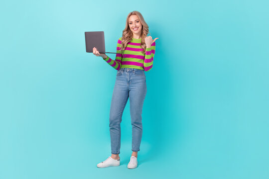 Full length photo of pretty cheerful lady wear striped pullover texting modern device thumb empty space isolated teal color background