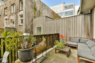 an outside area with furniture and plants in the fore - image is taken from inside, showing how it's made