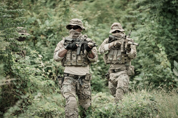Fototapeta premium United States Army ranger during the military operation. Professional marine soldiers training with weapon on a military range.