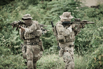 Fototapeta premium United States Army ranger during the military operation. Professional marine soldiers training with weapon on a military range.