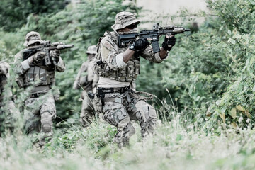 United States Army ranger during the military operation. Professional marine soldiers training with weapon on a military range.