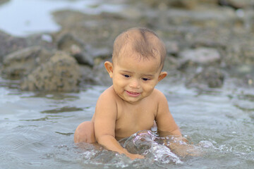 Rihan Husein Rohingya boy playing with water having shower beach