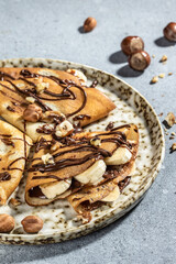 crepes with banana and chocolate. breakfast or dessert. vertical image. top view. place for text