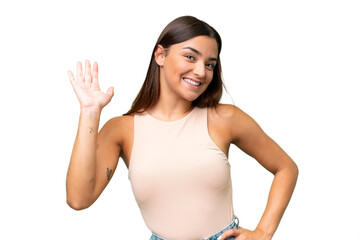 Young caucasian woman isolated on green chroma background saluting with hand with happy expression