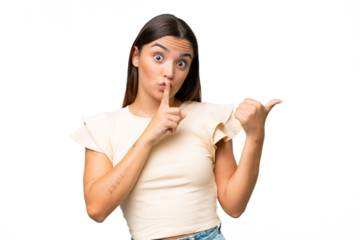 Young caucasian woman isolated on green chroma background pointing to the side and doing silence gesture