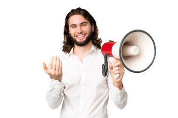 Young handsome man over isolated chroma key background holding a megaphone and inviting to come...