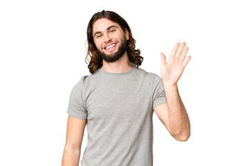 Young handsome man over isolated chroma key background saluting with hand with happy expression