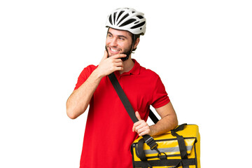 Young delivery man with thermal backpack over isolated chroma key background looking to the side