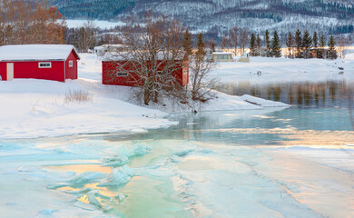 Beautiful winter landscape with old fishing red cabin (boathouse) boat at sunset - Red wooden...