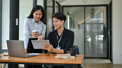 A handsome Asian male office worker is talking and sharing his ideas with a female colleague