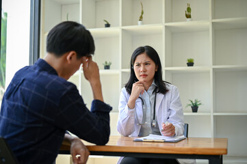 Obraz premium A stressed and serious Asian female doctor is having a serious meeting with a patient