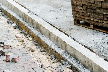 Paving and installation of a curb on a footpath. Construction of a sidewalk on a city street. Close-up. selective focus
