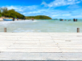 Wooden table, wooden bridge in blurred sea background