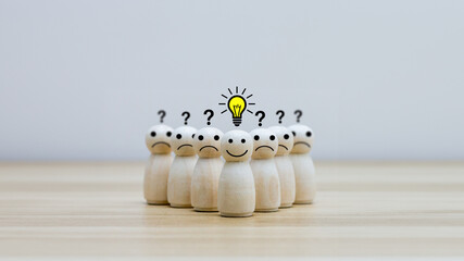 Smiley wooden human with light bulb and others human with question mark for creative thinking and...