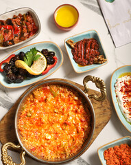 Traditional Turkish Breakfast served with traditional turkish tea on marble table, menemen, a traditional Turkish dish, prepared for breakfast