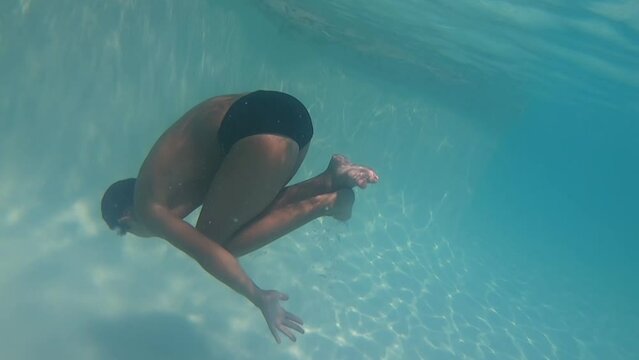 A boy doing a flip underwater 