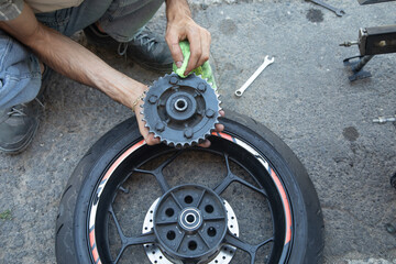 Man repairing motorcycle gear star. Maintenance, repair motorcycle