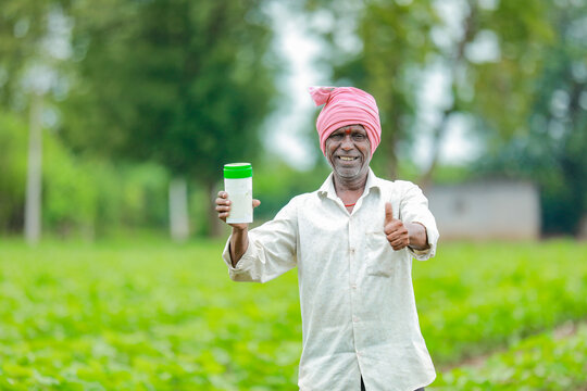 Indian happy farmer holding empty Bottle in hands, happy farmer showing white Bottle