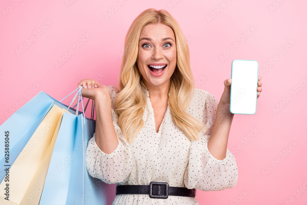 Sticker Photo portrait of attractive blonde woman shopping bags show white blank screen wear trendy white clothes isolated on pink color background