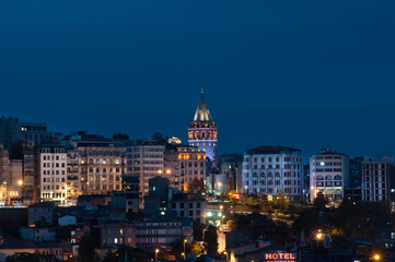 Fototapeta na wymiar The Istanbul skyline with the iconic Galata Tower lit up at night on the European side of the Bosporus straight, Turkey. .