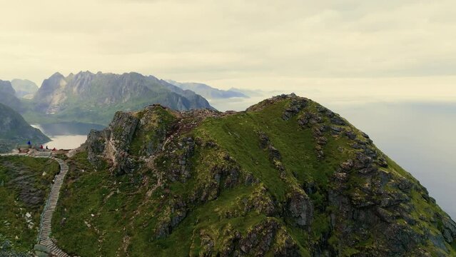 Drone zooms out from the top of the fjord to reveal a stone staircase for tourists