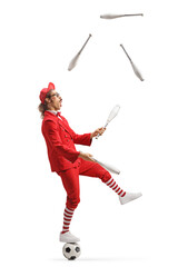 Man in a red suit standing on a football and juggling