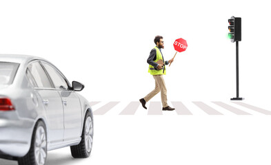 Full length shot of a man carrying books and a stop sign on a street in front of a car
