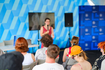 Woman speaking in front of audience on conference