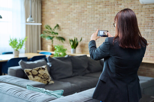 Woman real estate agent photographing furnished apartment