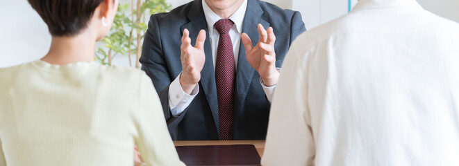 夫婦に営業するビジネスマン