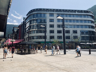 Tourists strolling through the shopping streets of Andorra la Vella on a summer's day.