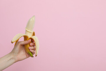 Condom on a banana on a light background, place for text