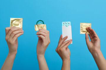 Fototapeta Condoms in hand on a blue background obraz