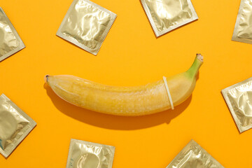 Condom on a banana on a yellow background