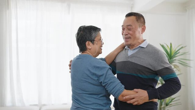Asian elderly couple dancing together while listen to music in living room. Happy couple dancing together. Love moment, Senior asian couple lifestyle, Happy expression