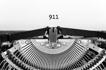 911 word closeup being typing and centered on a sheet of paper on old vintage typewriter mechanical