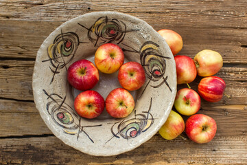 fresh apples in a bowl on wooden background