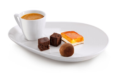 Café con leche en taza blanca con trufa de chocolate, brownies y tarta de yema. Latte coffee in white cup with chocolate truffle, brownies and yolk tart.