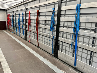 View inside the semi-trailer. Tie straps for securing loads hang on the side aluminum boards