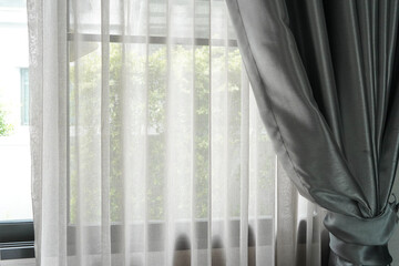Close up beautiful curtains on window blured green tree in backyard garden, stylish room interior design.