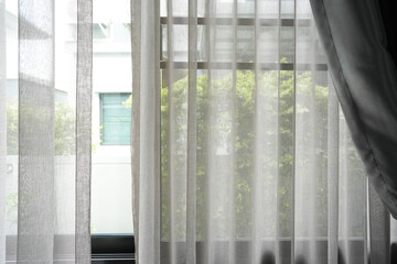 Beautiful curtains on window in stylish room interior green tree outside window.