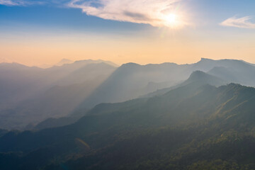 sunset behind mountain range with beautiful sun ray in the northern of thailand (Phu Chi Dao Chiang Rai Province)