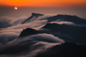 sunset behind the mountains with sea of cloud and beautiful sky in the northern of Thailand (Phu...